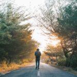 Neuanfang mit 40: 9 Dinge, die ich heute anders machen würde Ein Mann geht nachdenklich eine Landstraße entlang im goldenen Abendlicht – Sinnbild für den bewussten Weg in die zweite Lebenshälfte mit 40