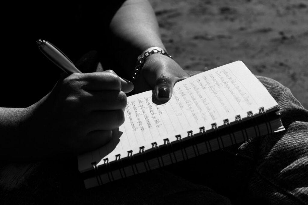 Eine Hand schreibt in ein Notizbuch – Sinnbild für den 30-Minuten-Neustart-Check und die eigene Reflexion über die zweite Lebenshälfte